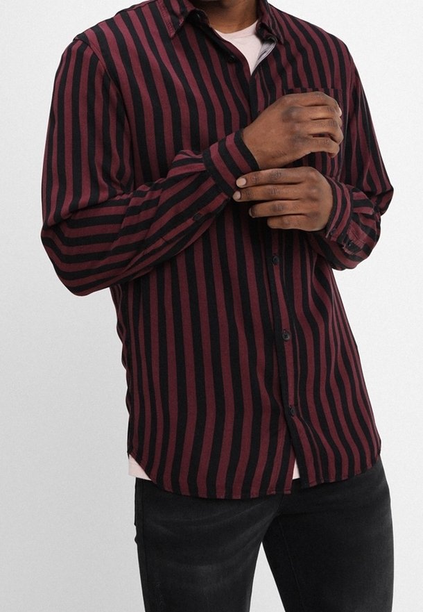 Striped shirt featuring vertical maroon and black lines, button-up design, long sleeves, and a curved hem. Made of soft material.