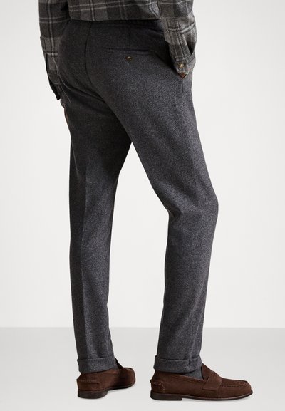 Szare wełniane spodnie o teksturowanym splocie, proste nogawki i podwinięte mankiety, z tylną kieszenią zapinaną na guzik.