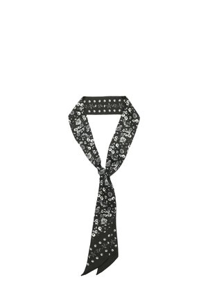 Zwarte zijden sjaal met witte en grijze bloemen- en stippenpatronen, losjes in een knoop gebonden.