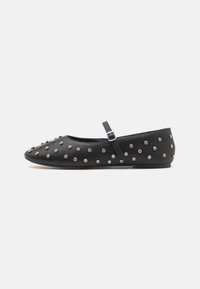 Black flats with a rounded toe, made of leather, featuring a strap with a buckle. Embellished with silver studs evenly across the surface.