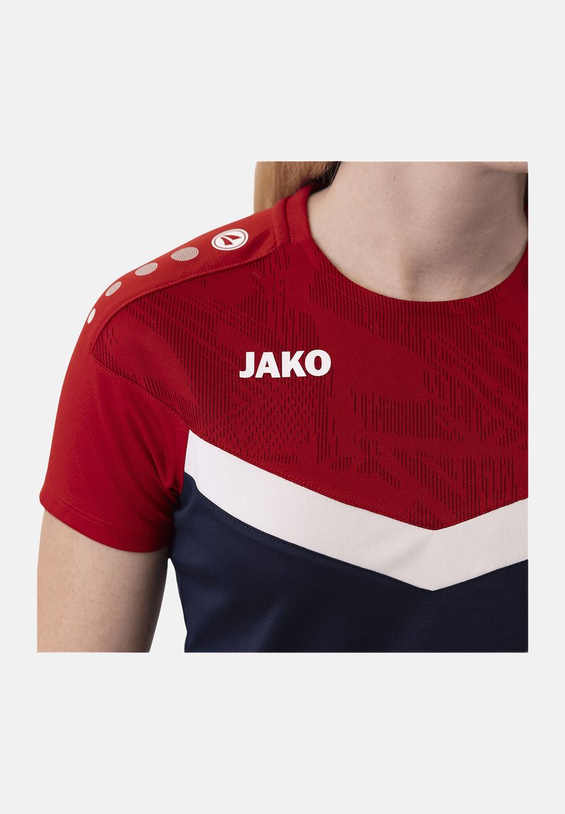 Chemise de sport à manches courtes rouge et marine, dotée d'un motif texturé, d'accents blancs et d'un logo "JAKO" sur la poitrine. Boutons sur l'épaule.