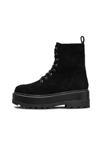 Botas de tobillo de ante negro con suela de plataforma gruesa negra, cordones en la parte delantera con ojales de metal y una pestaña en la parte trasera.