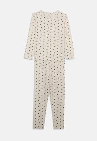 Krämfärgad pyjamaset med lång ärm och bruna prickar. Toppen har en rund halsringning och byxorna har resår i midjan för komfort.