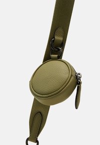 Pochette rotonda in pelle verde oliva con superficie testurizzata, attaccata a una larga tracolla verde testurizzata. Caratterizzata da accessori metallici neri e una zip.