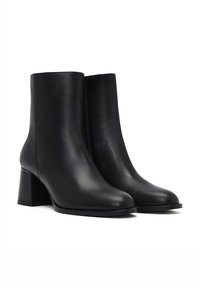 Bottines en cuir noir avec une finition lisse, bout arrondi et un talon large. Design simple sans quincaillerie visible ni motifs.