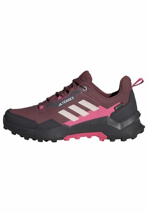 Buty do biegania po szlakach w kolorach burgundowym, czarnym i różowym z wytrzymałą podeszwą, paskami Adidas oraz logo Terrex i Gore-Tex po bokach.
