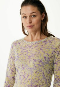 Dlouhý rukáv v průhledném, lehkém materiálu s květinovým vzorem v purpurových a žlutých odstínech a kulatým výstřihem.