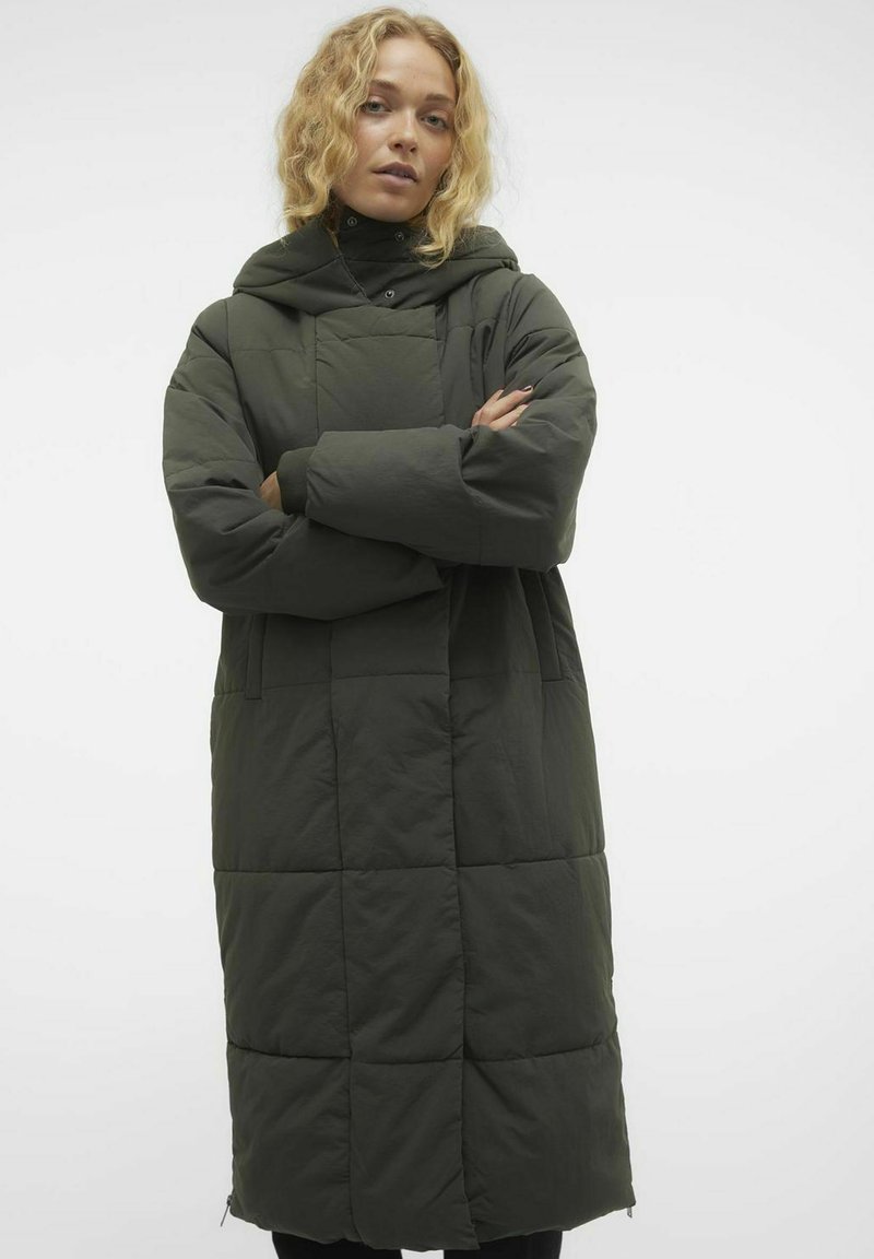 Abrigo acolchado, largo, de color verde oscuro con capucha; presenta un patrón acolchado y bolsillos laterales, fabricado con un material suave y ligero.