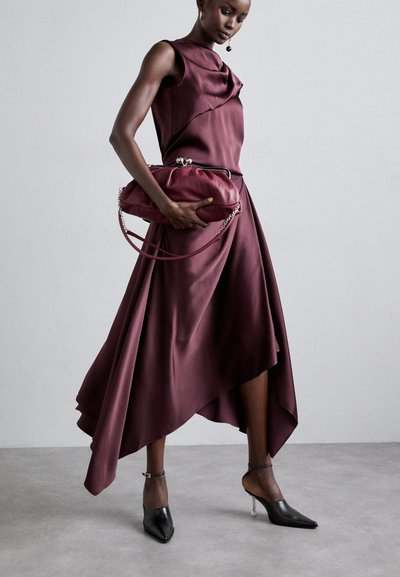 Burgundy satin asymmetrical dress with draped neckline and flowing skirt. Complemented by a burgundy clutch bag and black pointed heels.