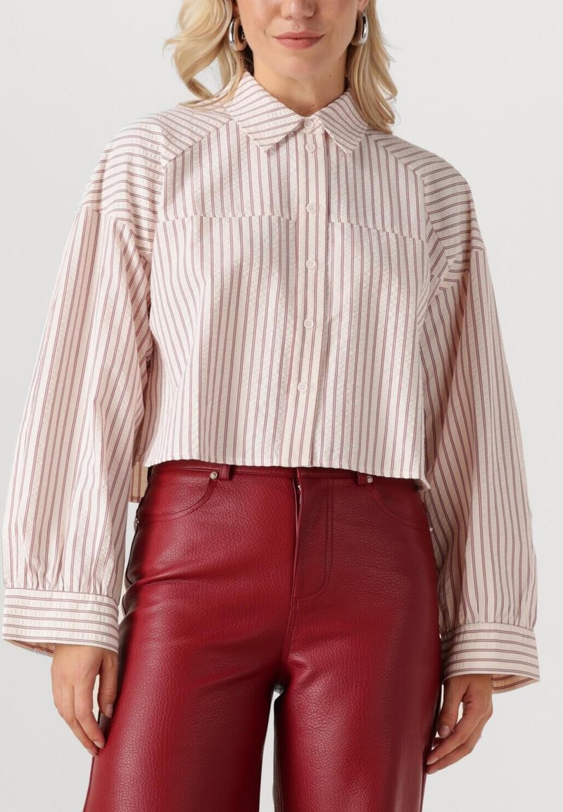 Gekraagde cropped shirt met witte en roze verticale strepen, knoopsluiting aan de voorkant en gepofte lange mouwen, gecombineerd met rode leren broek.