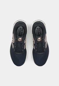 Dark blue athletic shoes with mesh upper, black laces, pink accents, and white sole featuring "Fresh Foam" branding on the insole.