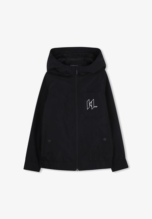 Veste noire à fermeture éclair avec capuche, dotée d'une poche avant, d'accents à boutons et d'un logo blanc sur la poitrine. Fabriquée dans un matériau lisse et léger.