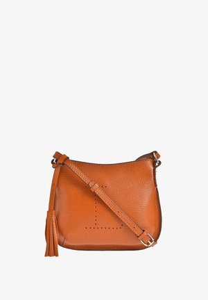 Sac bandoulière en cuir fauve avec sangle ajustable et détail pompon, présentant un motif décoratif perforé sur le devant.