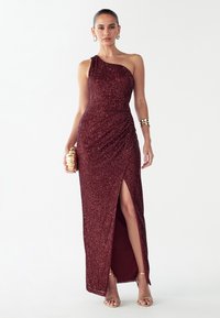 Burgundia värvi litritega õhtukleit ühe õlaga disainiga, kroogitud tekstuuri ja kõrge säärelõhikuga. Sobitatud kuldsete aksessuaaridega.