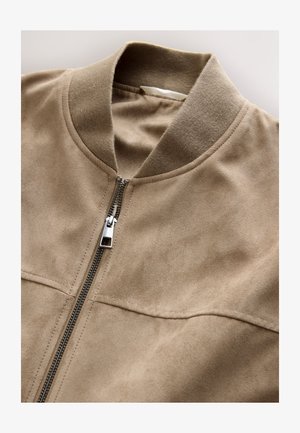 Beige Wildleder-Bomberjacke mit Kragen, Frontreißverschluss und zwei horizontalen Taschen. Weiche Textur und glatte Oberfläche, minimale Nähte.
