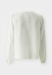 Blusa bianca a maniche lunghe con un sottile motivo a righe, scollatura rotonda e maniche arricciate, realizzata in tessuto leggero.