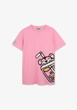 T-shirt en coton rose avec un grand graphisme d'un ours tenant une boisson colorée, avec des contours et accents noirs sur le devant.