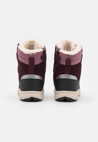 Bordeaux schoeisel met een zachte bontvoering, een combinatie van suède en synthetische materialen, en een grijze rubberen zool voor grip.