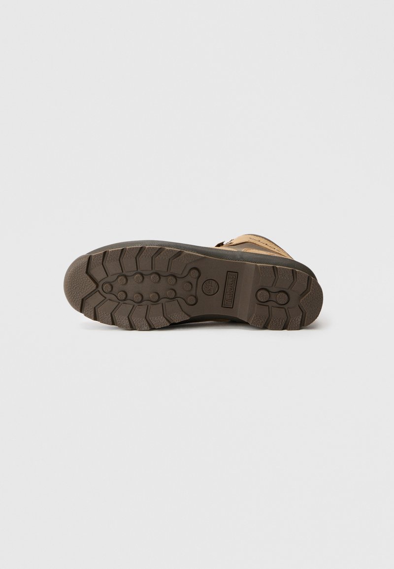 Brown leather boot with a textured rubber sole featuring zigzag treads for traction. The outsole shows a rounded toe and durable construction.