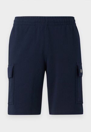 Shorts cargo bleumarin cu talie elastică, buzunare laterale și un material texturat. Prezentă un mic logo verde pe buzunarul stâng.