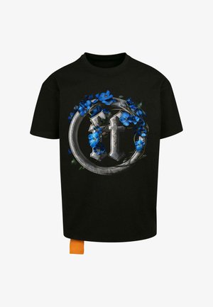 T-shirt en coton noir avec un grand graphisme de lettres argentées entourées de fleurs bleues et de feuilles vertes. Comprend une étiquette orange à l'ourlet.