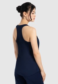 Top atletico senza maniche azul navy con design curvo sul retro. Tessuto morbido e leggero, adatto per l'abbigliamento sportivo.