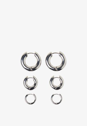 Silverfärgade hoopörhängen i tre storlekar, med en polerad yta och cirkulär design med lås. Slät textur och modern form.