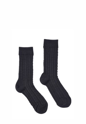 Calze di cotone nere con una texture a coste verticali e talloni rinforzati. Lunghezza a metà polpaccio con un orlo liscio, progettate per comfort e vestibilità.