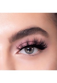 Närbild av ett öga med långa, dramatiska svarta ögonfransar, ljusrosa ögonskugga och en grå iris med bruna inslag, mot en slät hud.