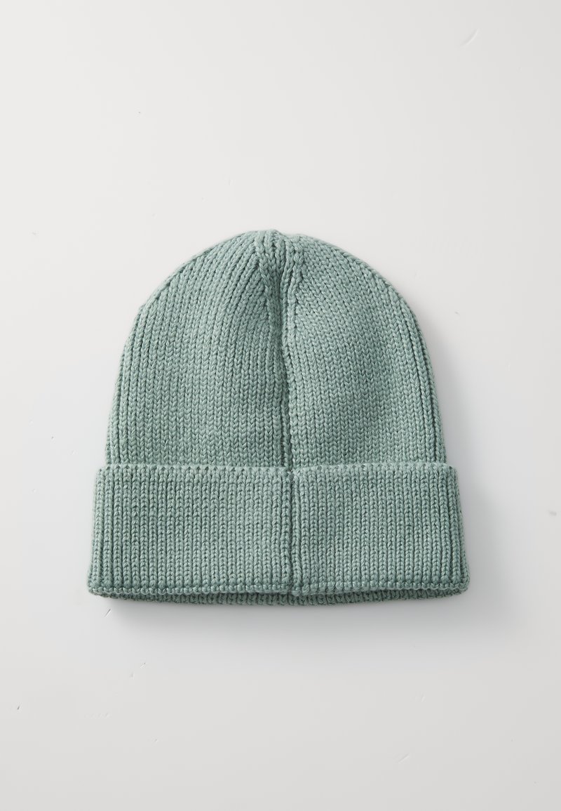Bonnet en tricot de couleur vert menthe doux, doté d'un revers côtelé replié et de détails de couture subtils, avec un sommet arrondi et décontracté.