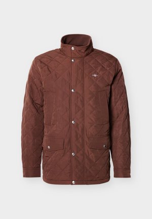 Chaqueta marrón acolchada con cuello alto, cierre de botones a presión y dos bolsillos en el pecho. Tejido liso con patrón de diamantes y detalles plateados.