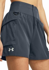 Tummanharmaat urheilushortsit, jotka on valmistettu kevyestä kankaasta. Shortsissa on korkea vyötärö, säätönyöri ja sivutaskut. Under Armour -logo näkyvissä.