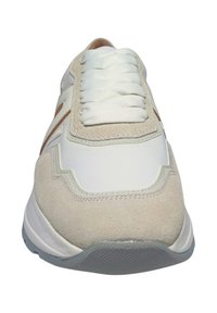 Weiße Sneaker mit einem Obermaterial aus Wildleder und Synthetik, strukturierten grauen Sohlen und flachen weißen Schnürsenkeln. Die Seite hat ein braunes Akzentdetail.