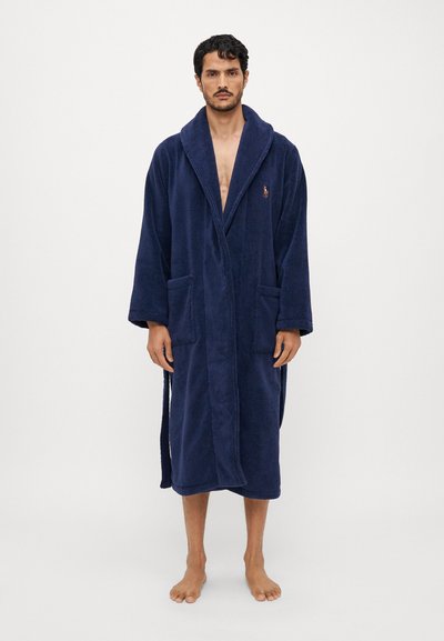 Accappatoio blu navy in morbido tessuto terry, con colletto a scialle, due tasche frontali e cintura da annodare. Dettaglio con logo ricamato.