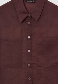 Dunkelbraune Button-Down-Hemd mit zwei Brusttaschen und einem spitzen Kragen, Größe S mit dem Etikett "CALLIOPE."