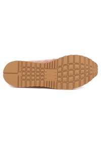 Suela de goma marrón con un patrón de agarre texturizado, que presenta surcos profundos y formas elevadas para una mejor tracción. Material superior suave de color claro visible.