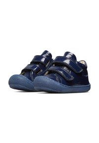 Zapatos de charol azul marino con dos correas de Velcro, punta redondeada, suela de goma texturizada y un acabado suave.