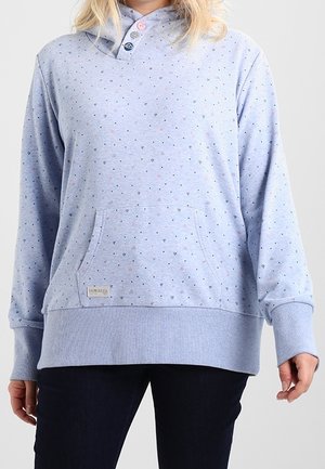 Lichtblauwe hoodie met kleine hartjespatronen, drie kleurrijke knopen bij de hals, een voorzak, gedragen met een donkere broek.