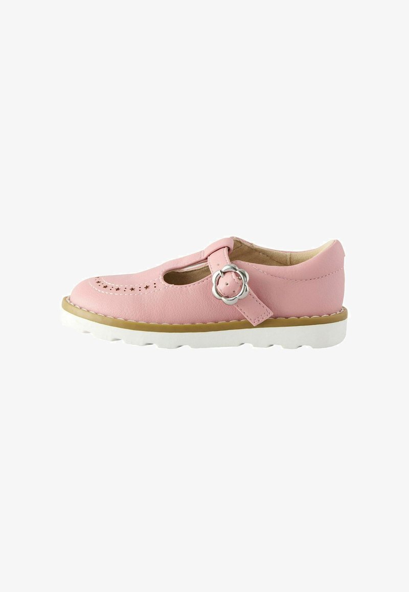 Chaussure Mary Jane en cuir rose avec une boucle argentée en forme de fleur, perforations en forme d'étoile et semelle en caoutchouc blanche.