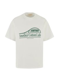 Tricou alb din bumbac cu un imprimeu grafic verde care prezintă textul "Another Cotton Lab" și un design cu linii curbe deasupra textului.