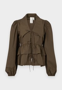 Blouse peplum brune avec un large col, des manches longues bouffantes et un détail de nœud à l'avant. Fabriquée en tissu coton léger avec une texture douce.