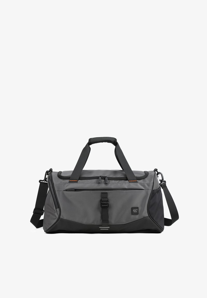 Sac de sport gris en tissu durable, doté d'une fermeture zippée, de deux poignées, d'une sangle réglable et d'accents noirs, avec une poche latérale.