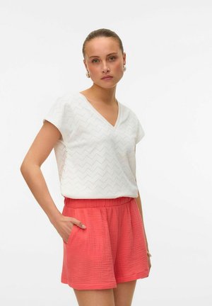 Witte, kortemouwige V-hals top met zigzagpatroon; gecombineerd met koraalkleurige, gestructureerde shorts met elastische taille en zijzakken.