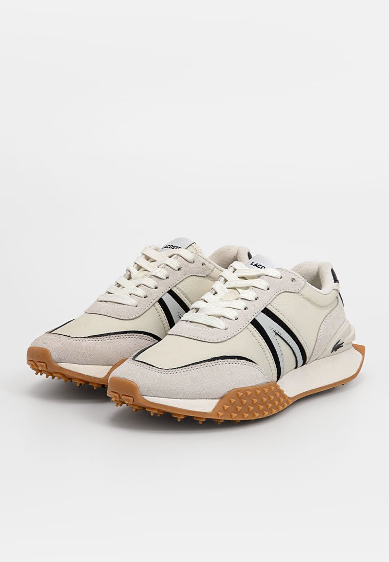Zapatillas de ante y lona beige con rayas negras y una suela de goma con tachuelas en punta. Diseño con cordones, puntera reforzada y detalle del logo.