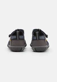 Niebieskie i szare buty outdoorowe z regulowanymi paskami, teksturowaną cholewką, amortyzowaną piętą oraz gumową podeszwą zapewniającą przyczepność.