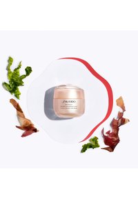 Shiseido Benefiance Rimpel Verzachtende Crème in een ronde, transparante glazen pot met een roze tint. Omringd door groene en rode zeewieraccenten.