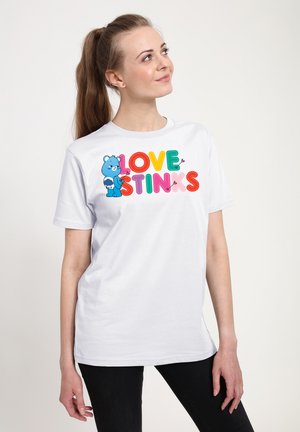 Hvid bomulds t-shirt med farverig "LOVE STINKS" tekst og et blåt bjørne grafik. Korte ærmer og klassisk pasform, simpel rund halsudskæring.