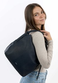 Zaino in pelle nera con una finitura testurizzata, forma affusolata e cordoncino laterale. Presenta elementi in metallo argentato e un dettaglio logo discreto.