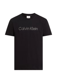T-shirt en coton noir à manches courtes, arborant un logo "Calvin Klein" argenté centré dans une police moderne. Texture lisse, coupe standard.
