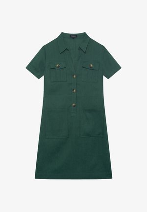 Robe verte à manches courtes en tissu texturé, dotée d'un devant à boutons, de deux poches poitrine et de deux poches inférieures avec boutons en laiton.